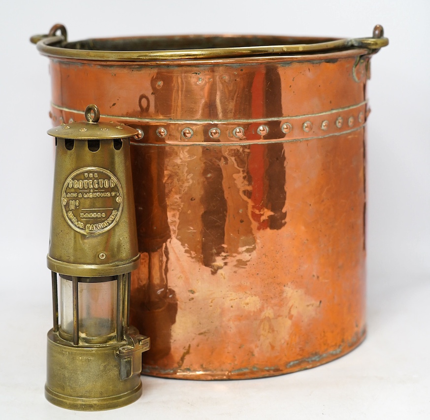 A brass handled copper coal bin and The Protector brass miner’s lamp, coal bin 30cm high. Condition - coal bin has some minor dents, miner’s lamp good